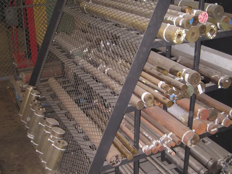Râtelier métallique chargé de barres et de tubes d'acier de différents diamètres